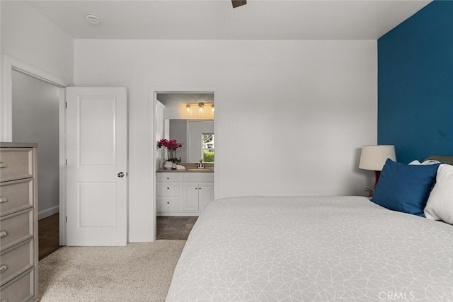 bedroom with ensuite bathroom, a sink, and carpet flooring