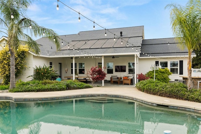 back of house with an outdoor pool, a patio, ceiling fan, outdoor lounge area, and a shingled roof