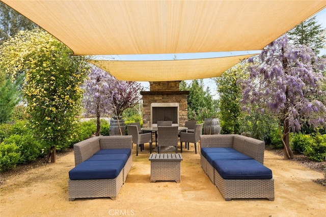 view of patio featuring outdoor dining area and an outdoor living space with a fireplace