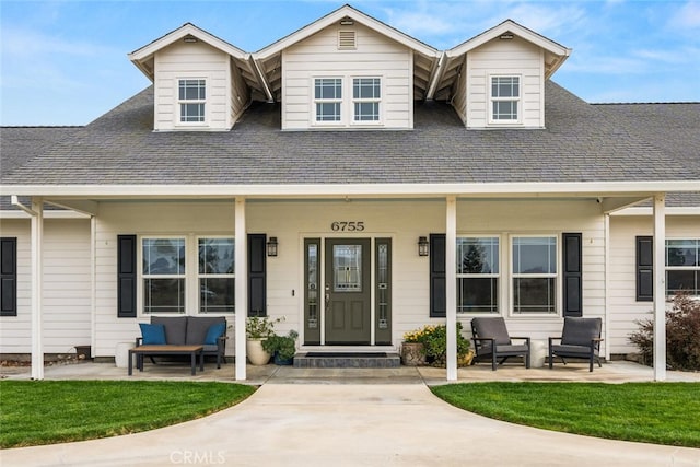 view of front facade featuring outdoor lounge area, a front yard, covered porch, and roof with shingles