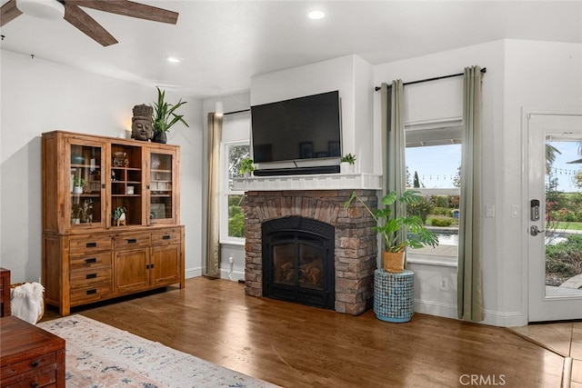 living area with ceiling fan, wood finished floors, recessed lighting, and a stone fireplace
