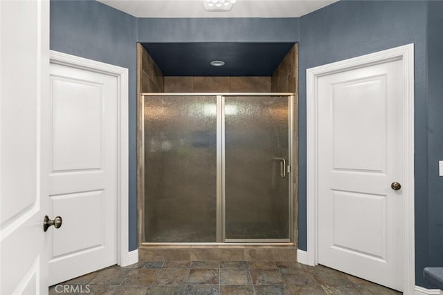full bath with stone finish floor and a stall shower
