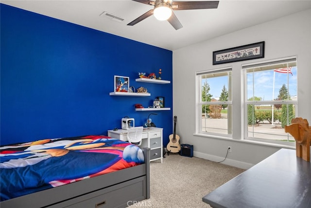 carpeted bedroom with baseboards, visible vents, and a ceiling fan
