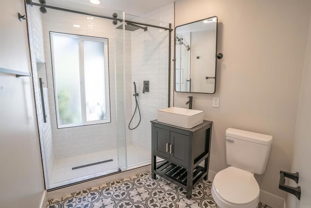 full bath featuring a shower stall, tile patterned flooring, toilet, vanity, and baseboards