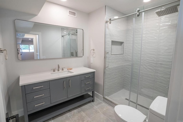 bathroom with toilet, vanity, and a stall shower