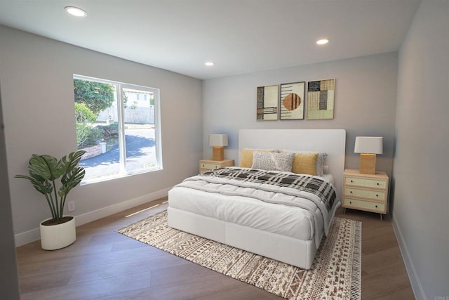 bedroom with baseboards, wood finished floors, and recessed lighting