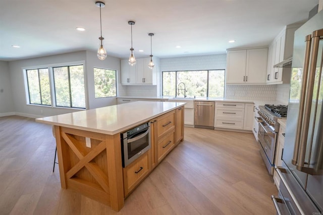 kitchen featuring open shelves, backsplash, high quality appliances, and a healthy amount of sunlight
