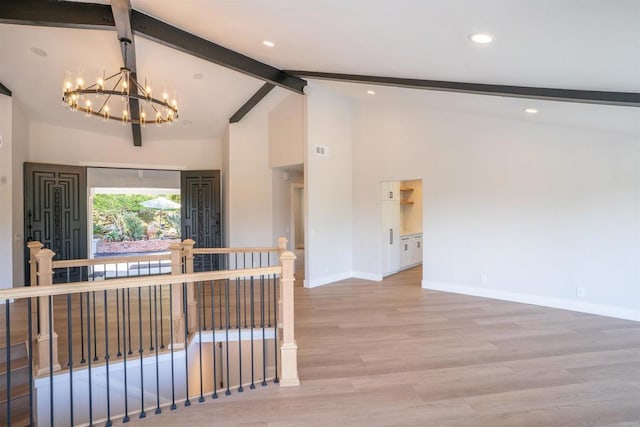 empty room featuring an inviting chandelier, wood finished floors, beamed ceiling, baseboards, and high vaulted ceiling
