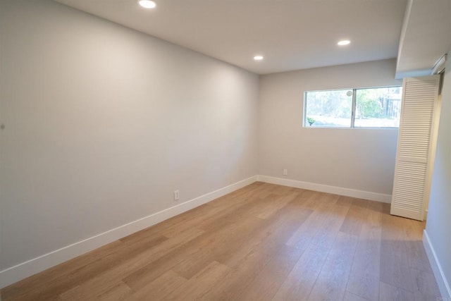 spare room featuring light wood-type flooring, baseboards, and recessed lighting
