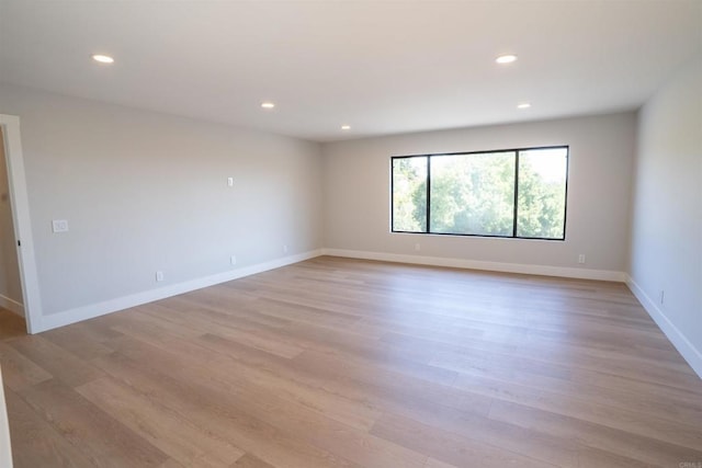 unfurnished room featuring recessed lighting, light wood-style floors, and baseboards
