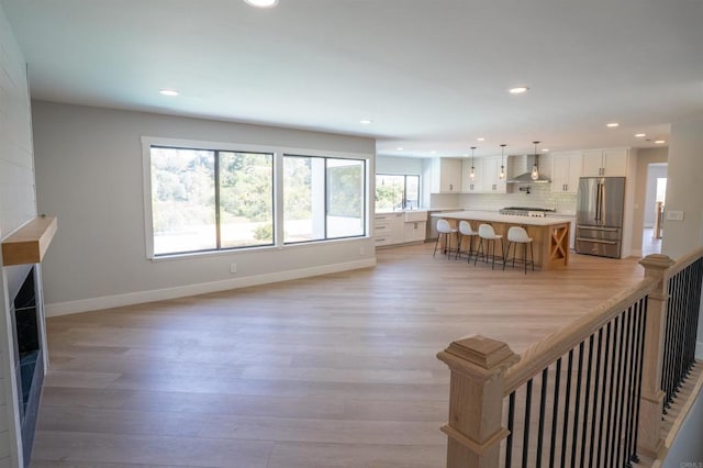 living area with recessed lighting, light wood finished floors, and baseboards
