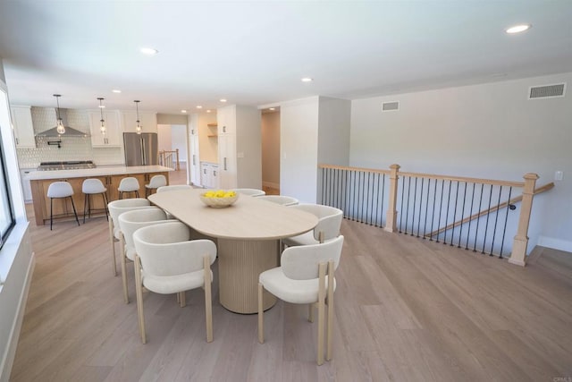 dining space featuring recessed lighting, light wood-type flooring, visible vents, and baseboards