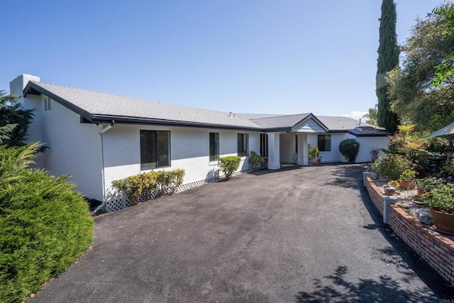 ranch-style house with driveway and stucco siding