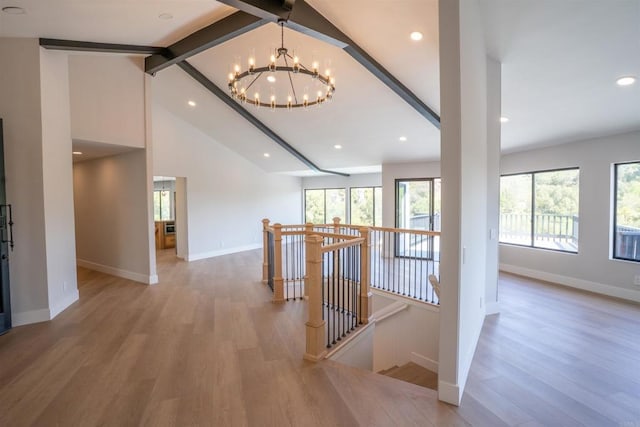 hall with an inviting chandelier, an upstairs landing, light wood-type flooring, baseboards, and lofted ceiling with beams