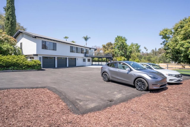 view of parking / parking lot featuring aphalt driveway and a garage