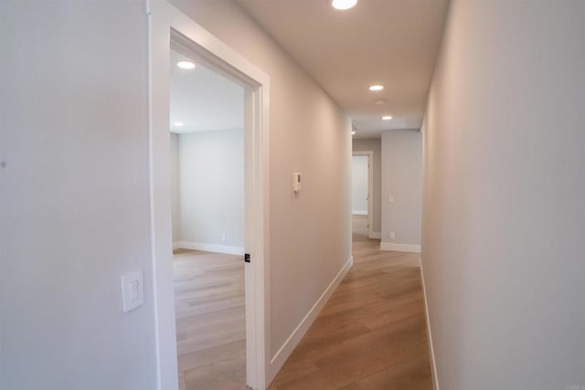 corridor with recessed lighting, light wood-style floors, and baseboards