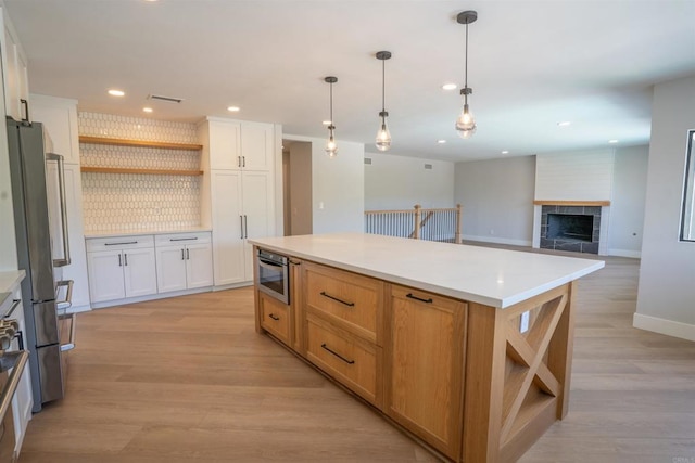 kitchen featuring open shelves, freestanding refrigerator, light wood-style flooring, white cabinetry, and recessed lighting