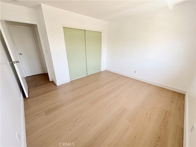 18131 Camino Bello Unit 4, Rowland Heights, CA 91748 - unfurnished bedroom featuring wood finished floors, a closet, and a textured ceiling