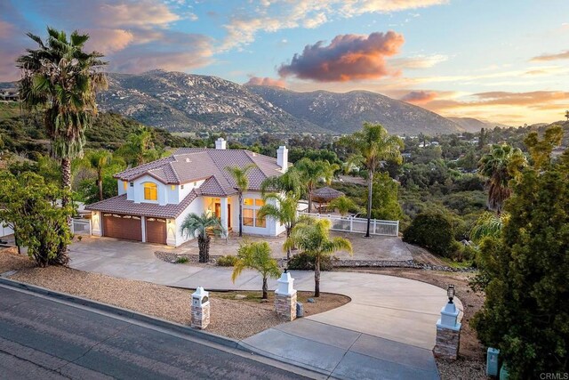 15881 Broad Oaks Rd, El Cajon, CA 92021 - mediterranean / spanish-style house with curved driveway, a tiled roof, a chimney, fence, and a mountain view