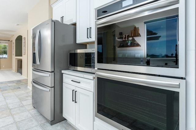 15881 Broad Oaks Rd, El Cajon, CA 92021 - kitchen featuring stainless steel appliances, white cabinets, arched walkways, and light countertops