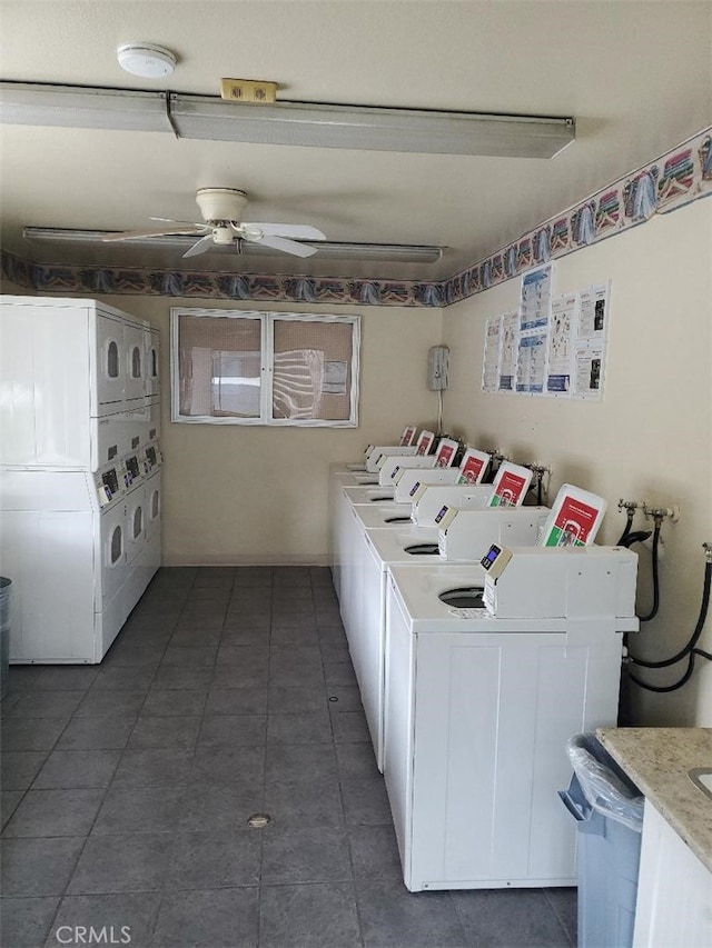 community laundry room featuring ceiling fan, washing machine and dryer, stacked washer / dryer, and dark tile patterned flooring