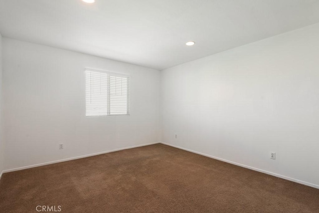 empty room with recessed lighting, baseboards, and dark colored carpet