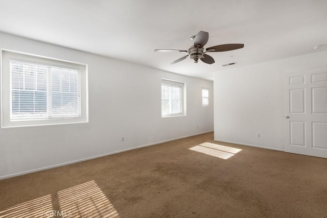carpeted empty room with visible vents, baseboards, and ceiling fan