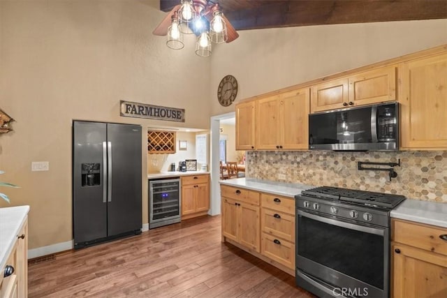 kitchen with wine cooler, light brown cabinets, appliances with stainless steel finishes, and ceiling fan