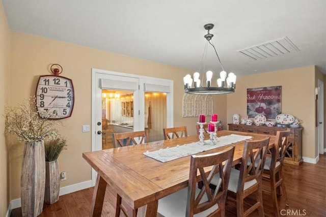 dining space with visible vents, baseboards, an inviting chandelier, and wood finished floors