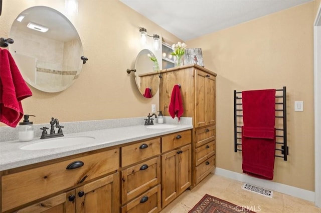 full bathroom featuring double vanity, visible vents, baseboards, and a sink