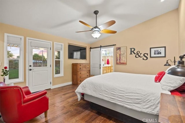 bedroom featuring multiple windows, lofted ceiling, baseboards, and wood finished floors