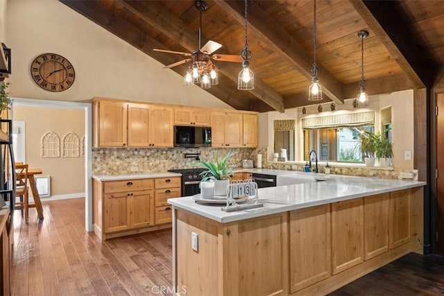 kitchen with backsplash, light brown cabinetry, wood finished floors, gas stove, and a sink