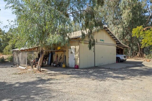 exterior space with a carport, an outbuilding, driveway, and a pole building
