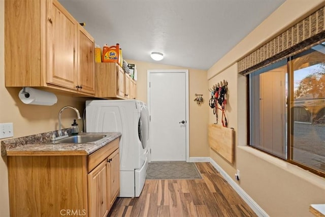 laundry area with cabinet space, wood finished floors, baseboards, and a sink
