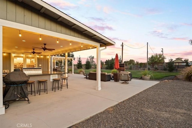 view of patio with ceiling fan, an outdoor living space, fence, and outdoor dry bar