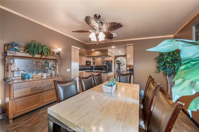 dining area featuring arched walkways, ceiling fan, and ornamental molding