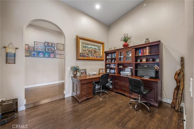 office space with arched walkways, baseboards, recessed lighting, and wood finished floors