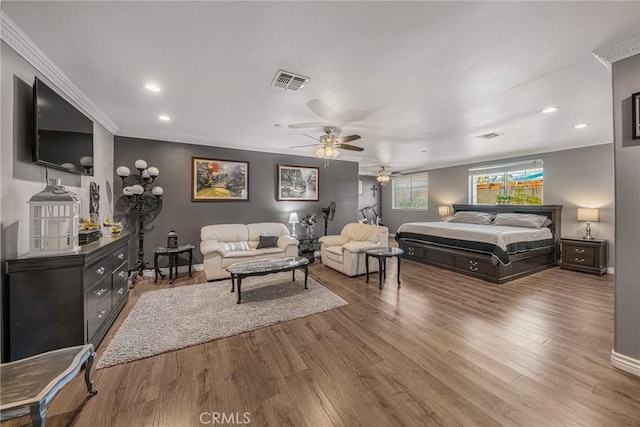 bedroom with recessed lighting, baseboards, wood finished floors, visible vents, and ornamental molding