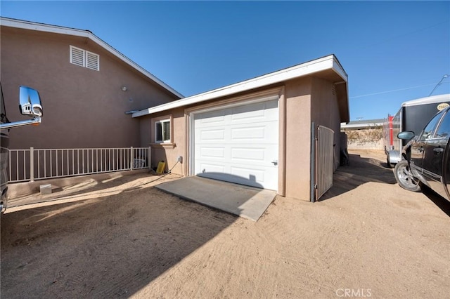 garage with fence and driveway