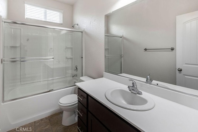 full bath featuring combined bath / shower with glass door, toilet, vanity, and a textured wall