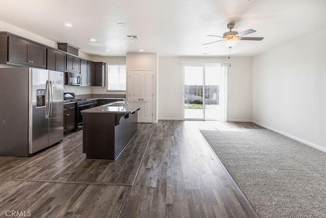 kitchen featuring visible vents, ceiling fan, dark brown cabinetry, open floor plan, and appliances with stainless steel finishes