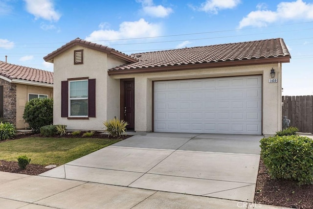 view of front of house featuring concrete driveway, a tiled roof, fence, and stucco siding