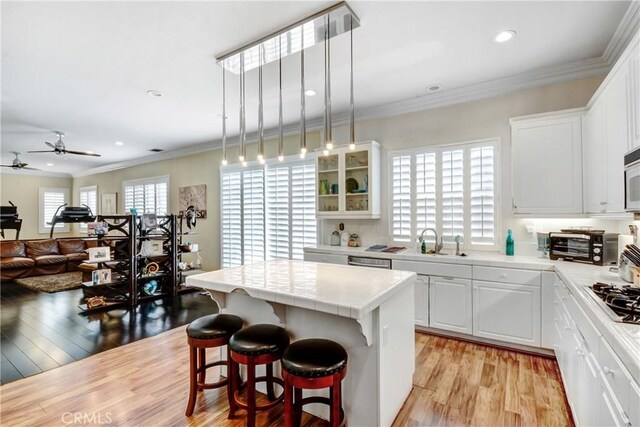 8345 Sunshine Ln, Riverside, CA 92508 - kitchen featuring crown molding, a center island, light countertops, and a sink
