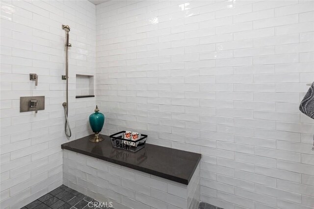 bathroom with tile walls and a tile shower
