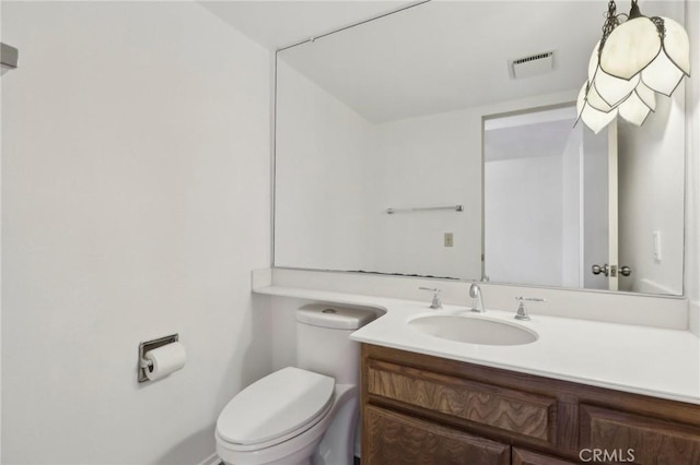half bathroom with visible vents, toilet, and vanity