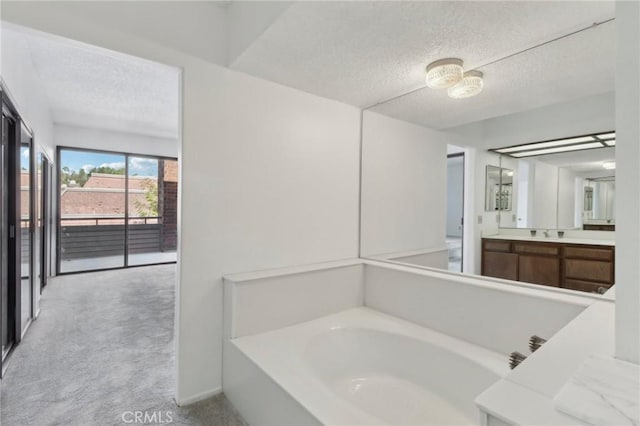 bathroom featuring a bath, a textured ceiling, and vanity