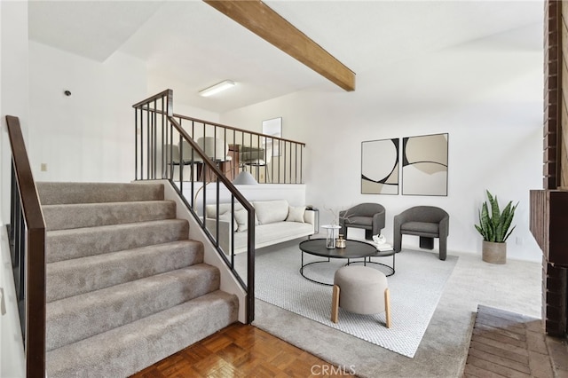 living room featuring stairway and beamed ceiling