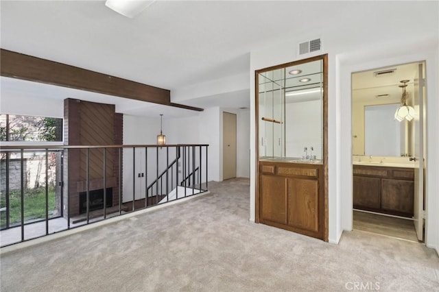interior space featuring wet bar, beamed ceiling, visible vents, and a sink