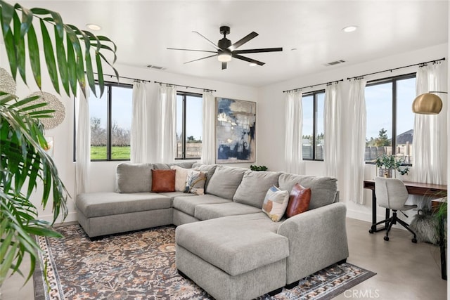 living area with ceiling fan, visible vents, and a healthy amount of sunlight