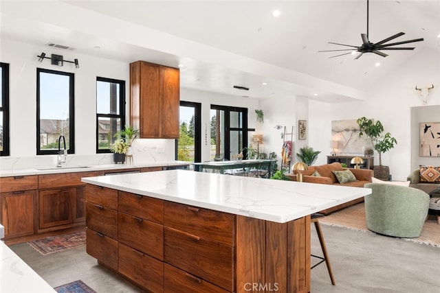 kitchen featuring recessed lighting, a sink, brown cabinetry, and open floor plan